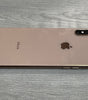 Apple iPhone XS Max in gold color lying face down showing dual camera and sleek design on wooden surface