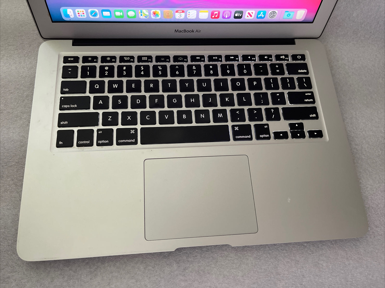 Silver Apple MacBook Air 13-inch with Intel Core i5 keyboard and trackpad showing partial screen and macOS Big Sur background