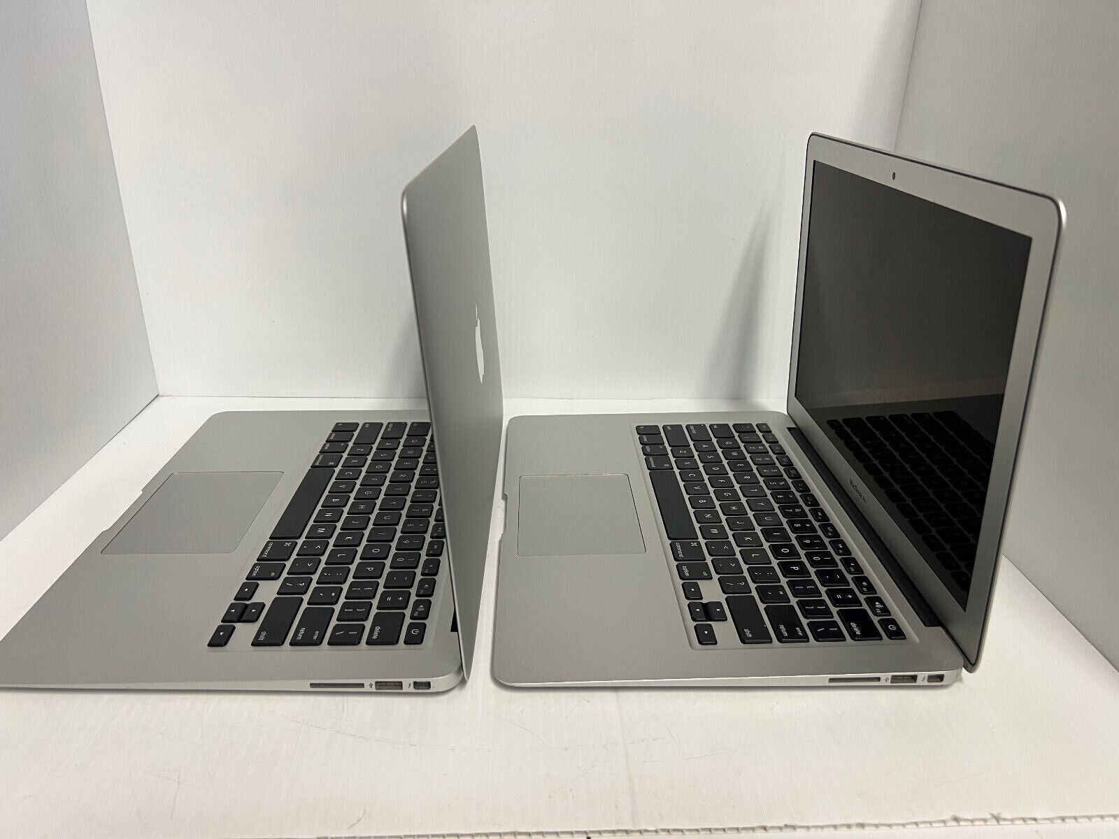 Two Apple MacBook Air A1466 13.3-inch Intel i5 laptops side by side, showing keyboard and screen in silver color