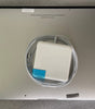 Bottom view of silver MacBook Air 13 inch 2013 model with charger placed on top showing rubber feet and label details