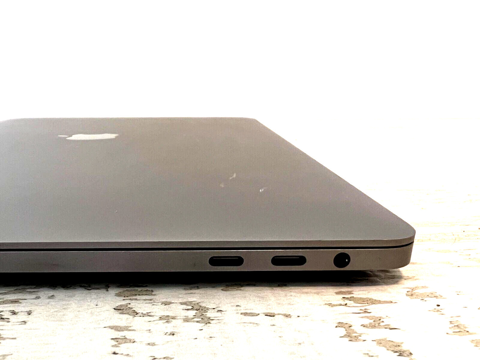 Space Gray Apple MacBook Pro 15-inch closed view showing dual Thunderbolt ports and headphone jack side profile