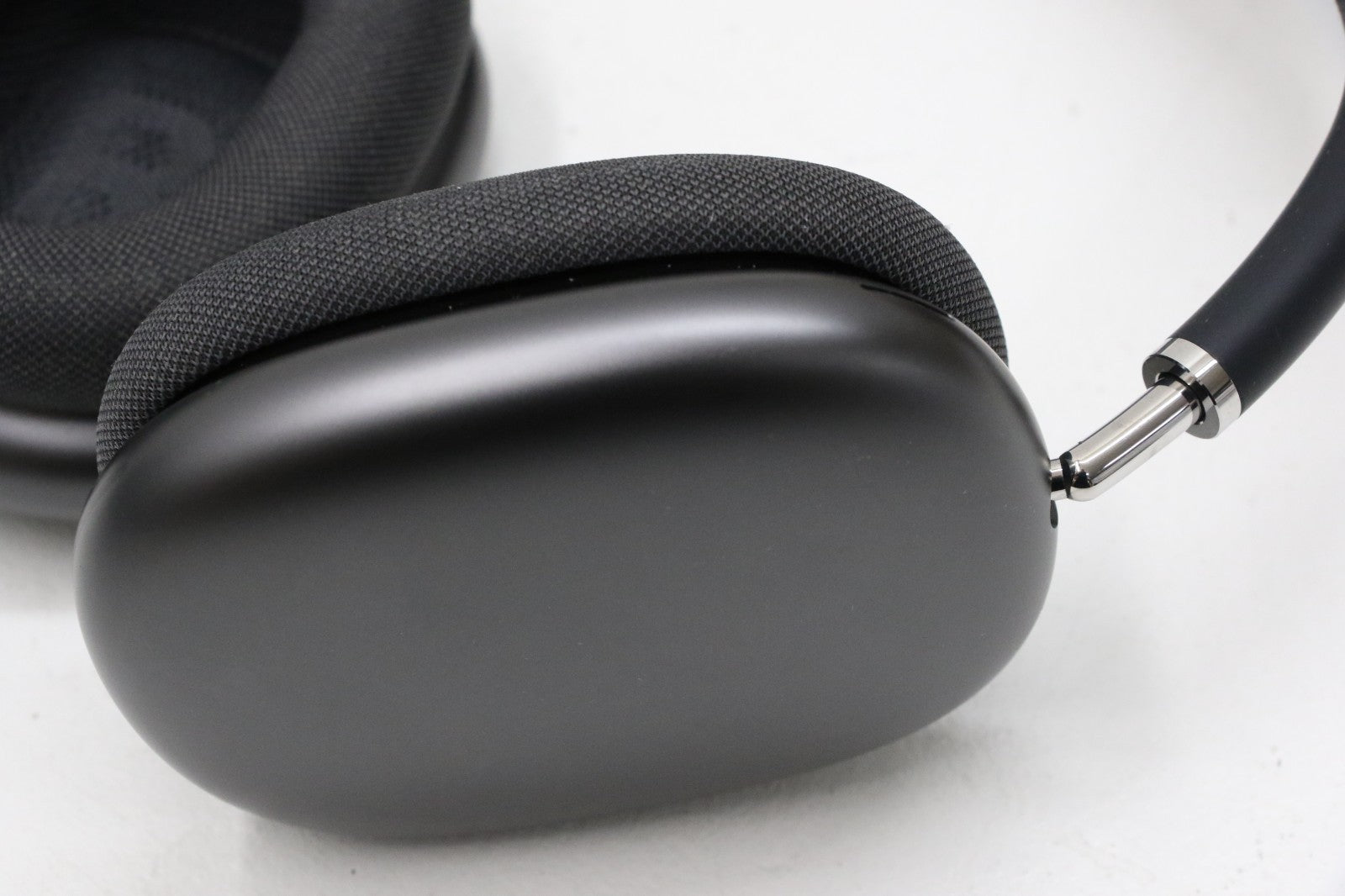 Apple AirPods Max wireless over-ear headset in space gray showing ear cup and headband connection close-up