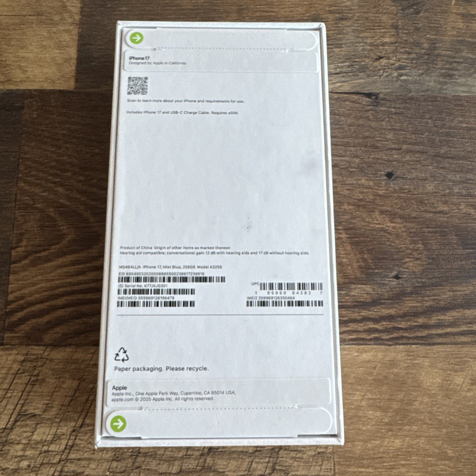 Sealed Apple iPhone 17 Mist Blue 256GB box showing back label on wooden surface in new condition