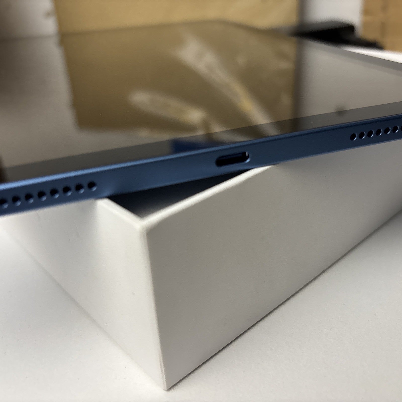 Blue Apple iPad 10th Gen 10.9-inch showing charging port and speaker grills on box in excellent condition