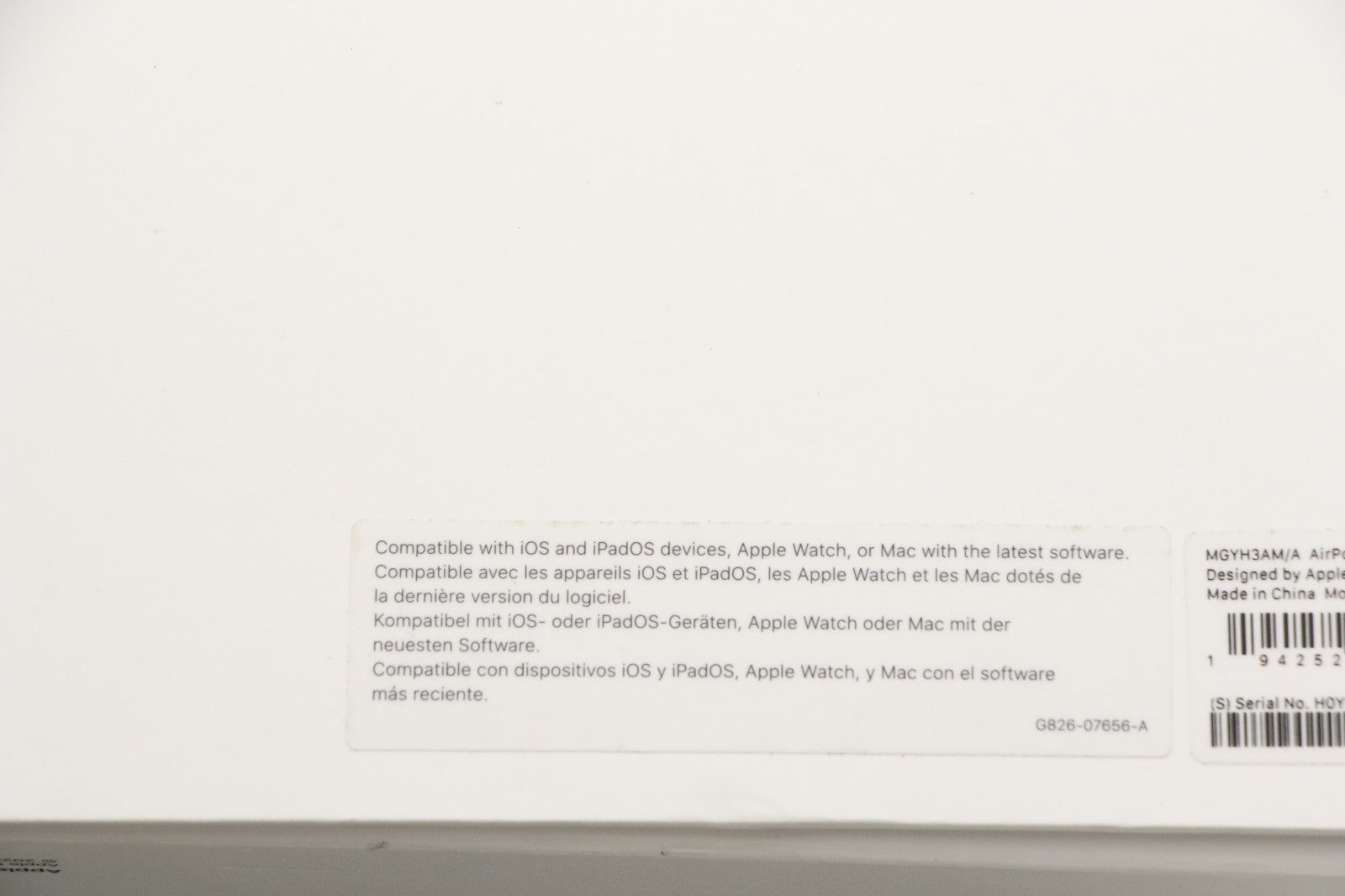 Back of white Apple AirPods Max Space Gray box showing compatibility and product information labels in multiple languages