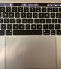 Apple MacBook Pro 15-inch keyboard and Touch Bar in silver with large trackpad and backlit keys, excellent condition