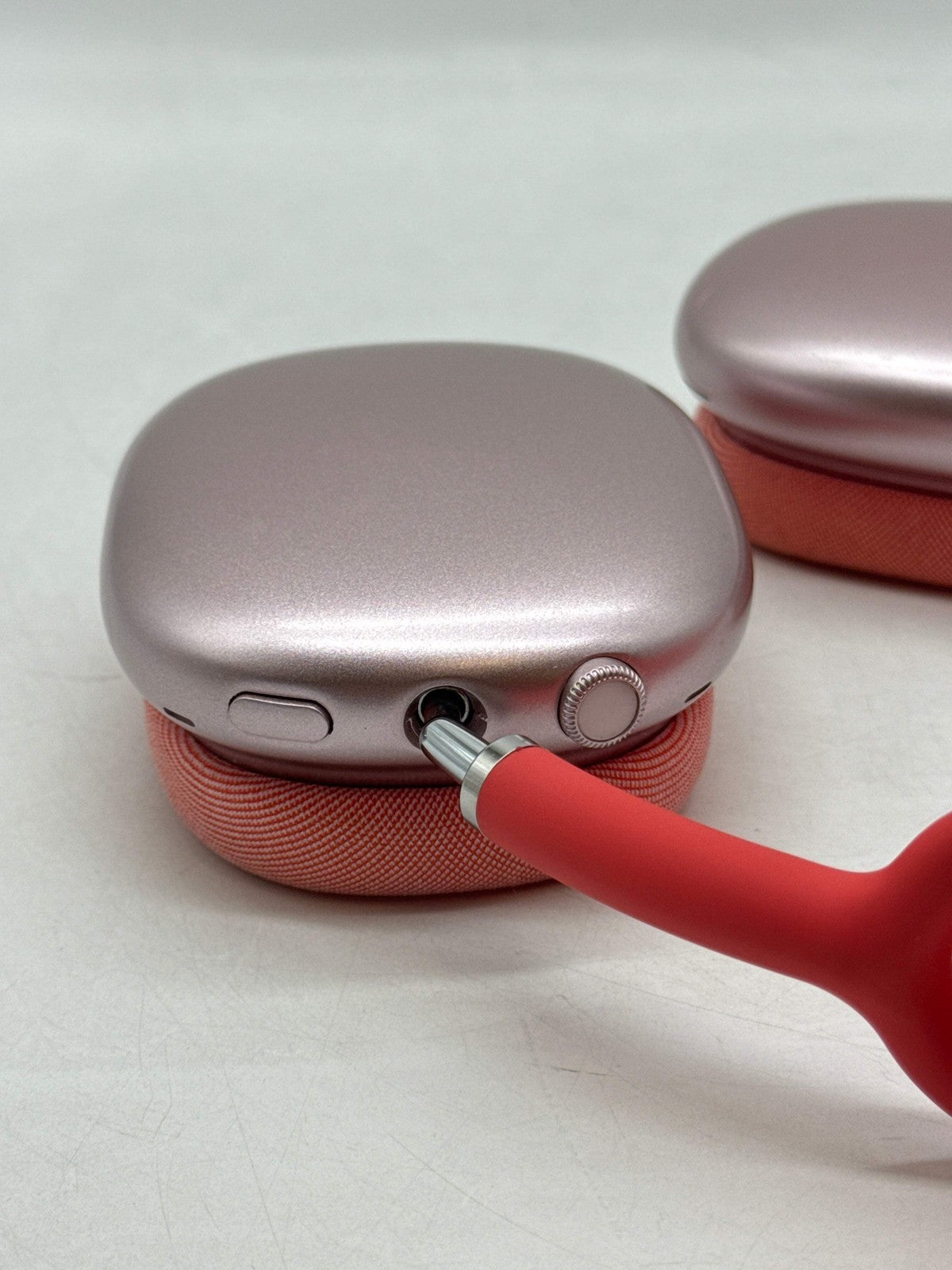Pink Apple AirPods Max A2096 over-ear headphones close-up showing ear cup with wired connection port and control knob