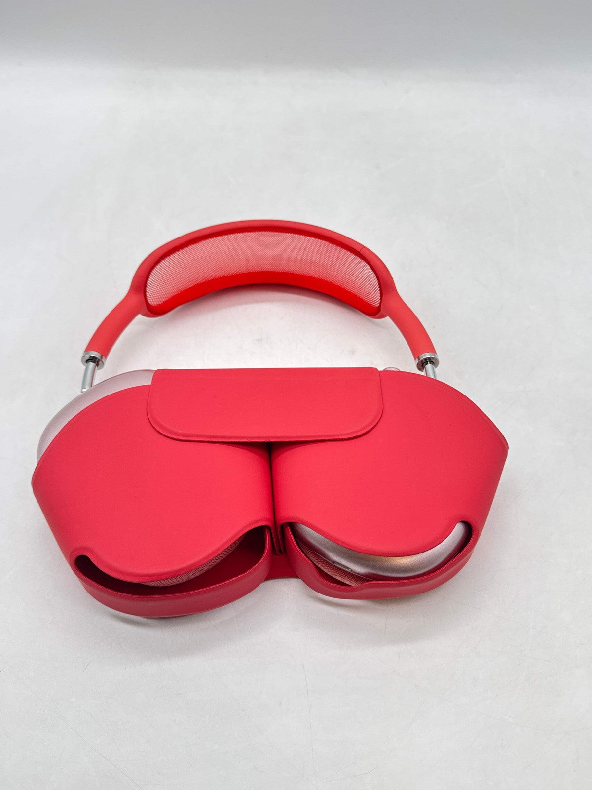 Pink Apple AirPods Max folded with ear cups together and mesh headband band visible on white background