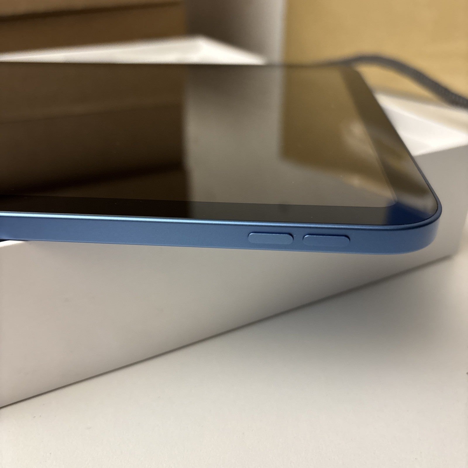 Blue Apple iPad 10th Gen 10.9-inch showing side buttons and part of screen in excellent condition with box background