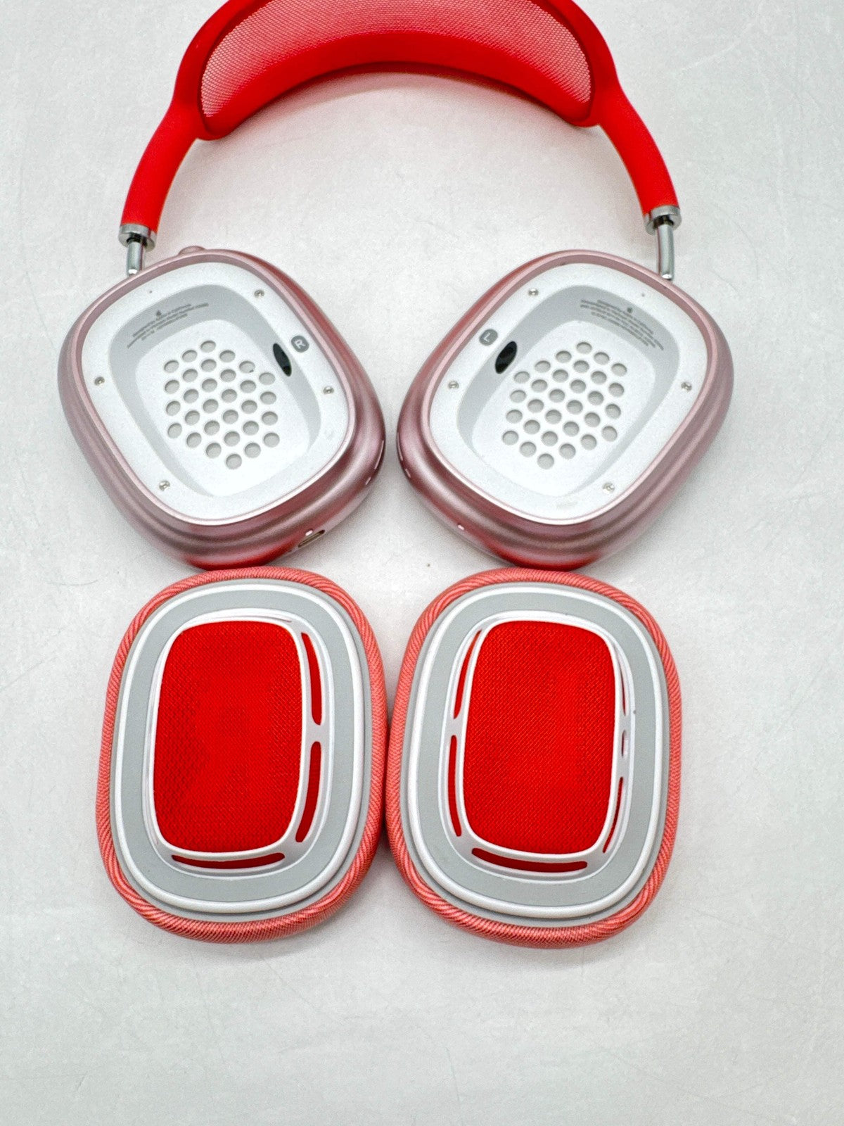 Apple AirPods Max A2096 over-ear headphones in pink with red mesh ear cushions detached, showing inner speaker details