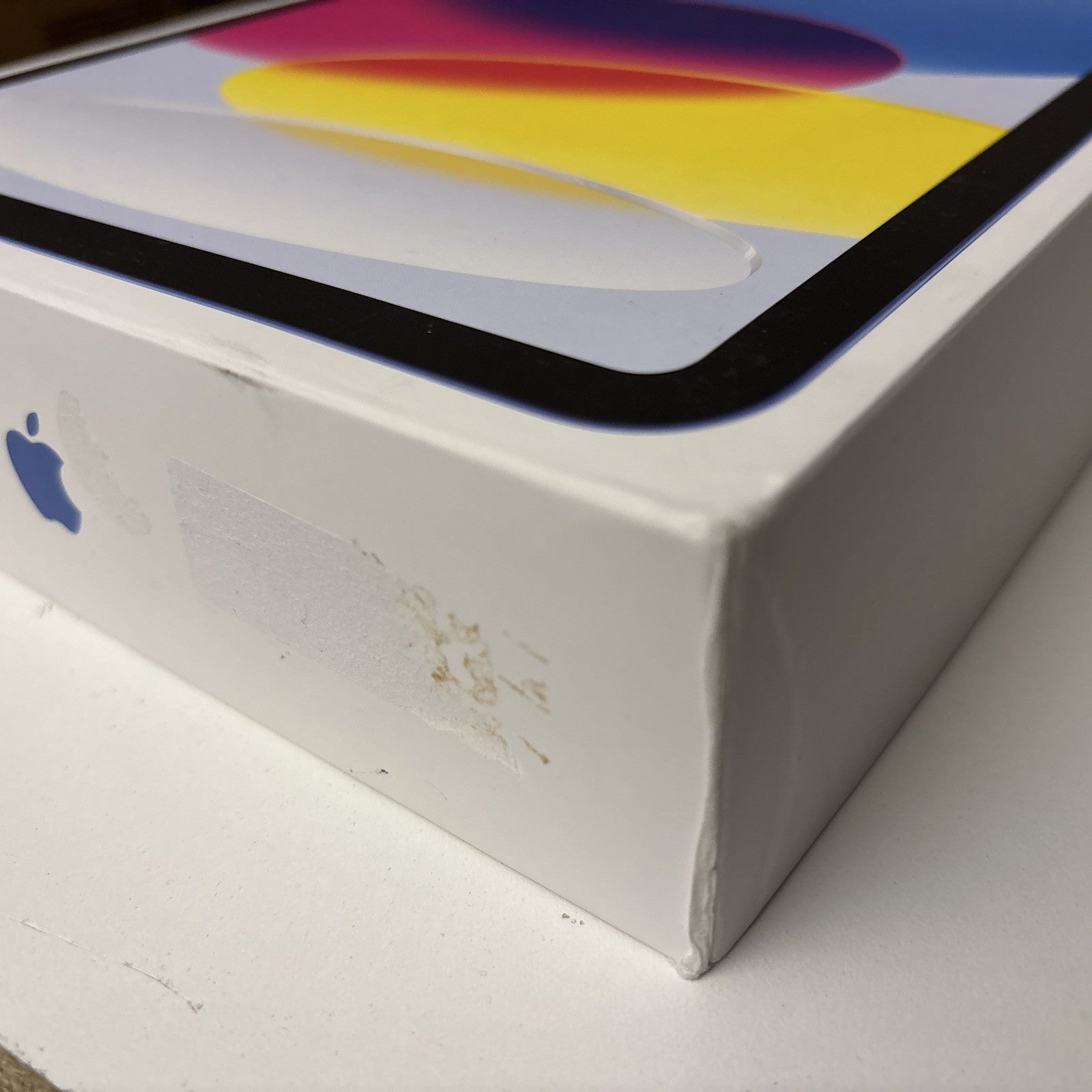 White box of Apple iPad 10th Gen 10.9 inch in blue showing corner with slight wear and Apple logo visible