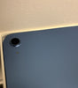 Close-up of blue Apple iPad 10th Gen 10.9-inch rear camera and body in excellent condition on white packaging surface