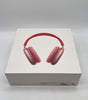 Apple AirPods Max pink over-ear headphones displayed on white retail box with red headband and cushioned ear cups