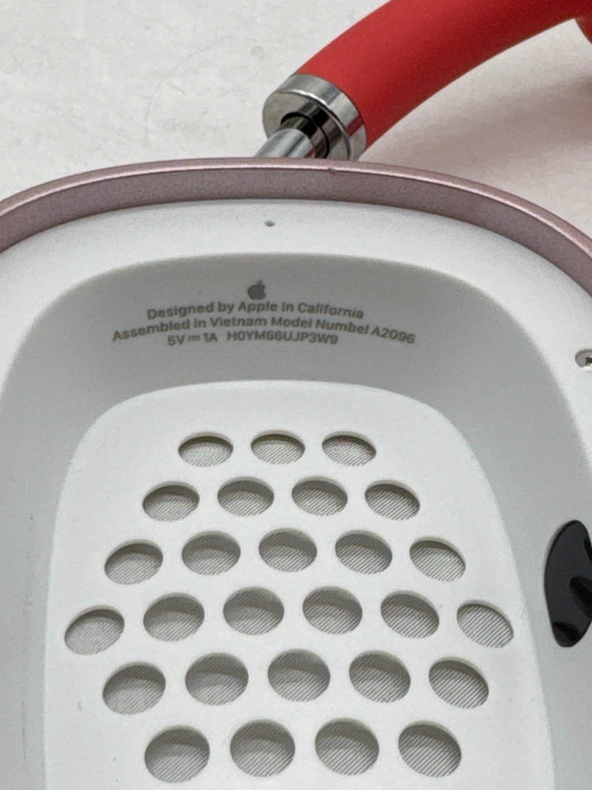 Close-up of Apple AirPods Max Lightning A2096 pink over-ear headphone interior showing speaker grille and text details