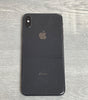 Black Apple iPhone XS Max with dual rear cameras placed on a gray wooden surface showing back view design and logo.