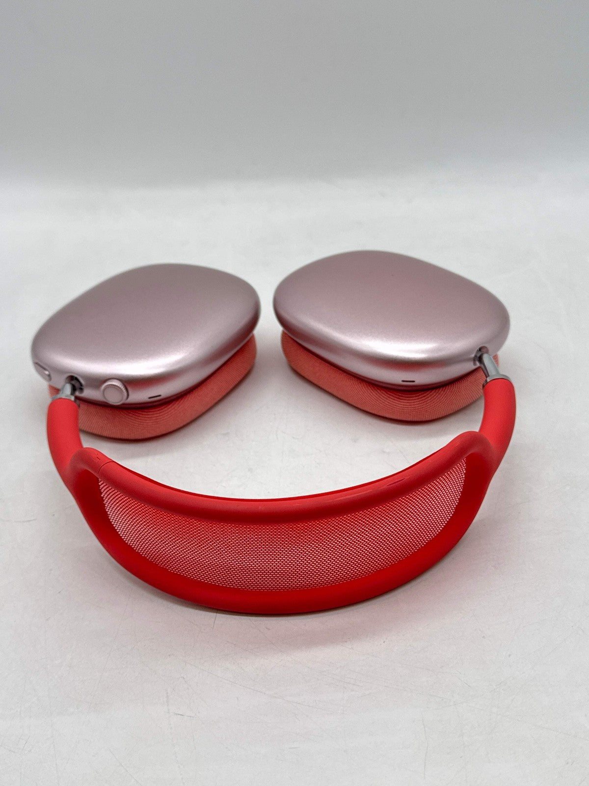 Apple AirPods Max Lightning A2096 over-ear headphones in pink with red headband and mesh cushion, shown front view.