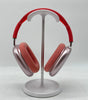 Apple AirPods Max Lightning A2096 over-ear headphones in pink with red headband, shown on white stand front view